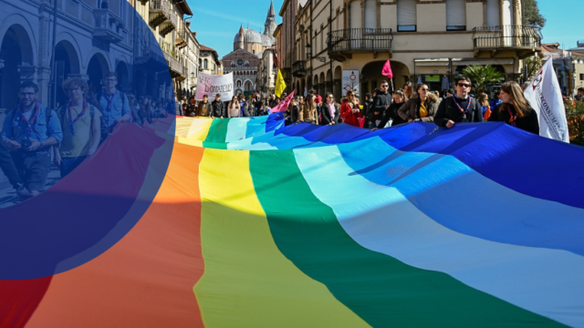 Corteo con persone in marcia con striscione della pace