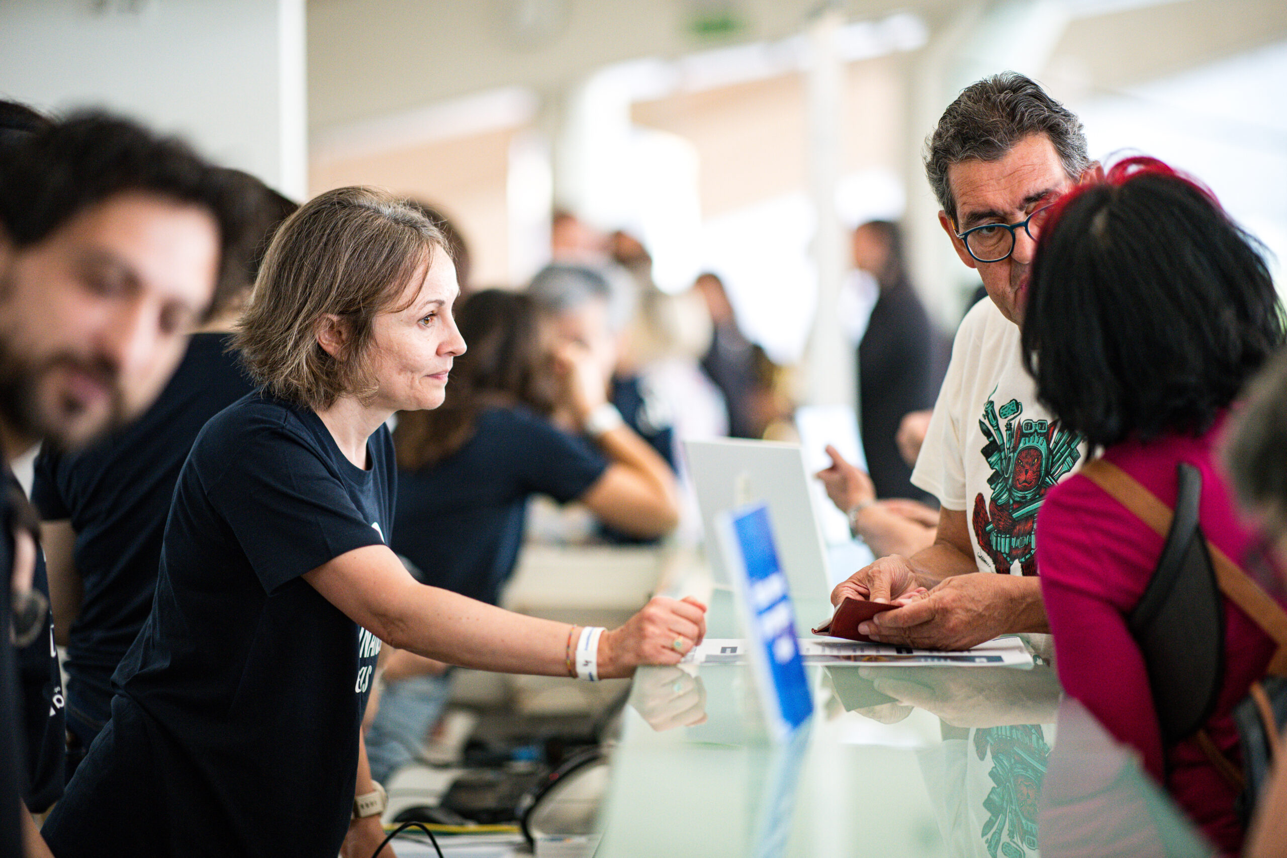 Soci durante l’assemblea dei soci a Valencia mentre conversano e si registrano al banco accoglienza.