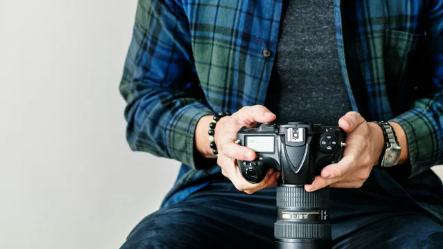 Uomo che tiene in mano una macchinetta fotografica.