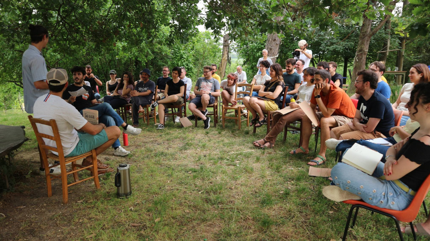 Ragazzi e ragazze seduti all'aria aperta che parlano di finanza etica